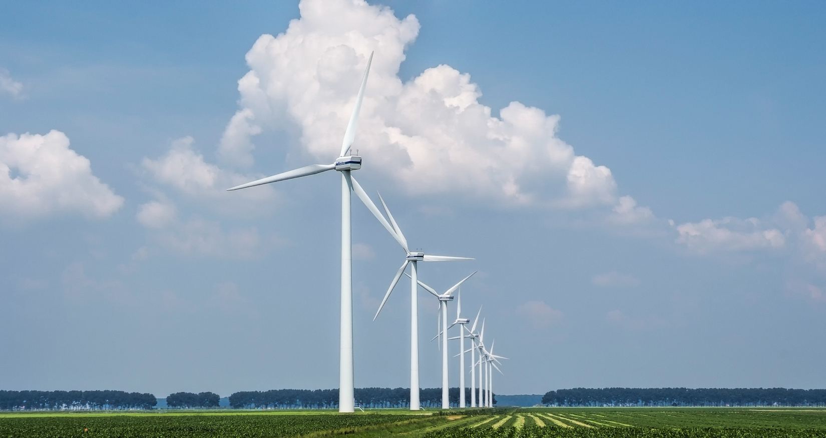 Wind turbines, solar array and battery storage units on a Neoserve renewable energy site